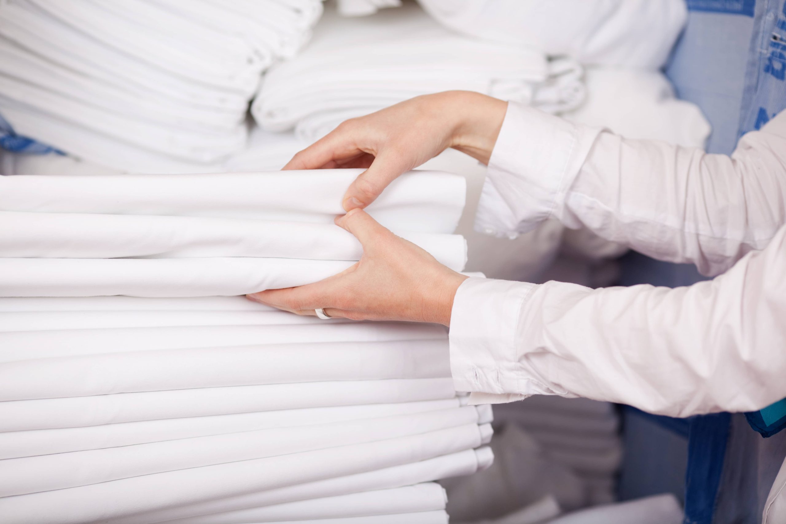 closeup-white-bedsheets-stacked-store-room-hotel(1)
